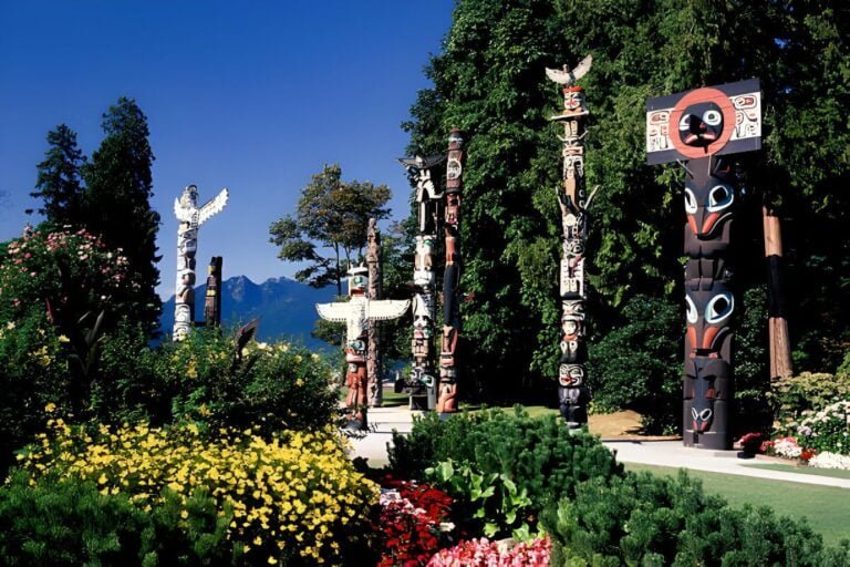 A scenic view of Stanley Park showcasing the lush rainforest, vibrant totem poles, and picturesque beaches.