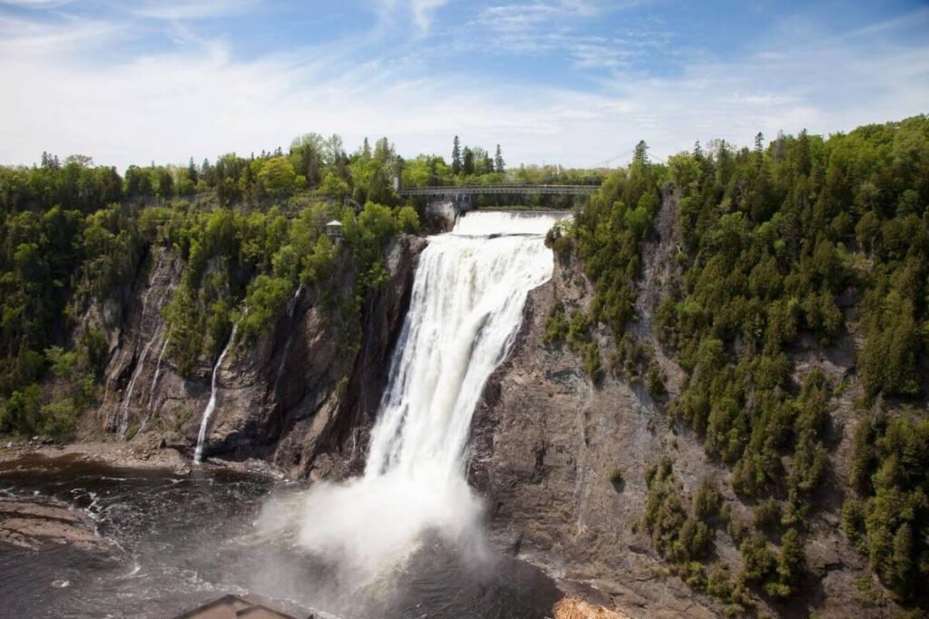 A breathtaking view of Montmorency Falls, showcasing its powerful cascade and the surrounding lush greenery.