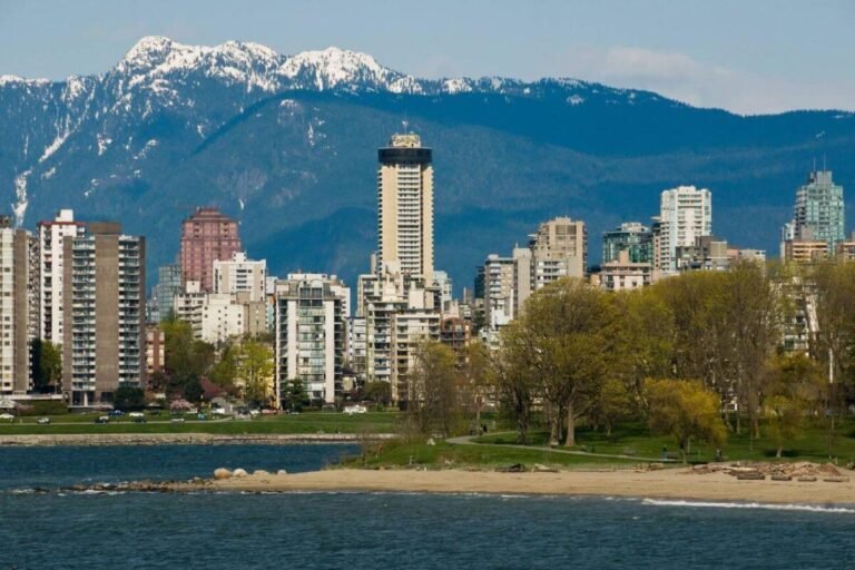 A scenic view of a Vancouver beach with people enjoying the sun, sand, and sea.